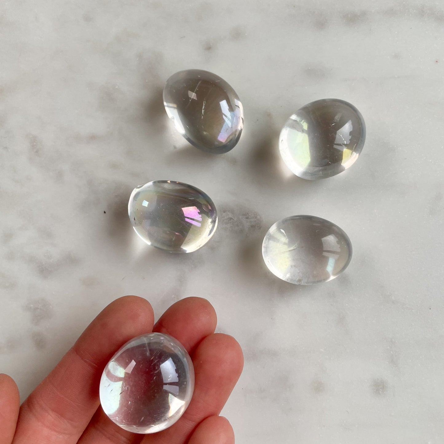 Regnbågsfärgad trumlade angel aura cuddle stone. Kronchakrat